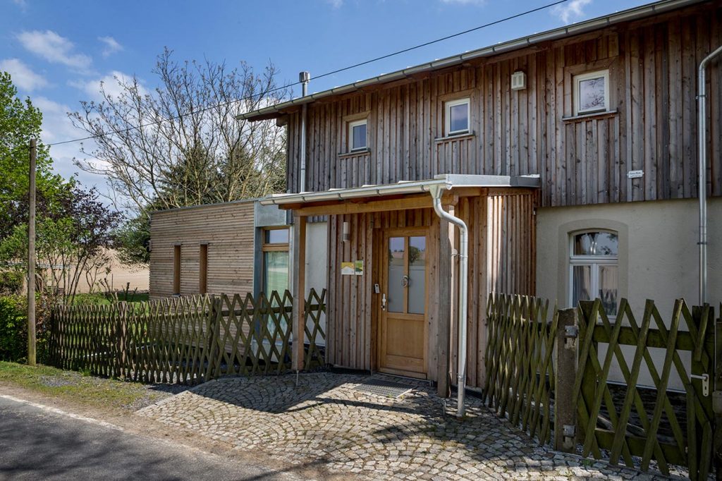 Bahnwärterhaus mit Holzfassade und Haupteingang im Vogtland