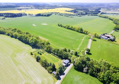 Luftaufnahme des Bahnwärterhauses mit weitem Blick über das grüne Vogtland