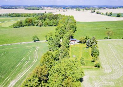 Vogelperspektive auf das Bahnwärterhaus zwischen Feldern und Baumallee im Vogtland